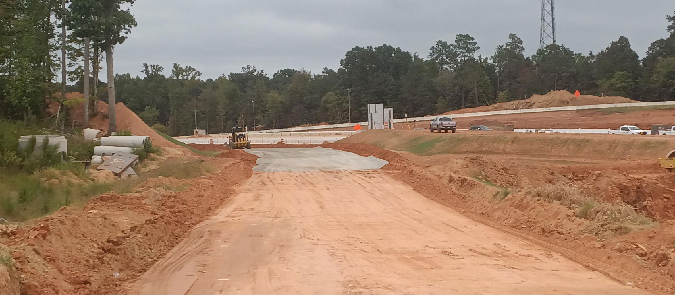 The construction of the new ramps for Exit 91 is underway.  After the soil is graded and compacted, a layer of macadam base stone is added as part of the pavement design. 
