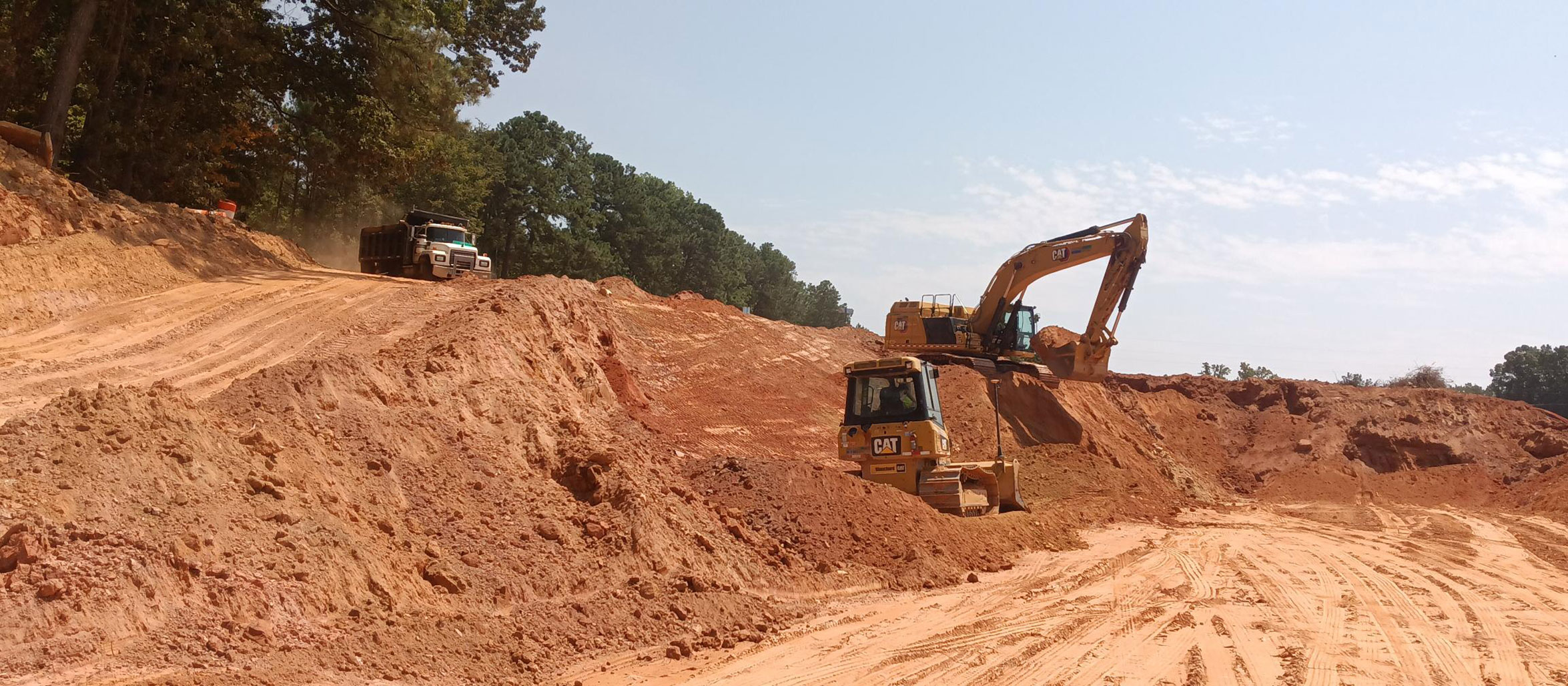 The grade of the future lanes is lowered by excavating the soil.  Excavated material is hauled to areas of the project that need embankments to raise the grade.  This is called balancing of the earthwork materials.