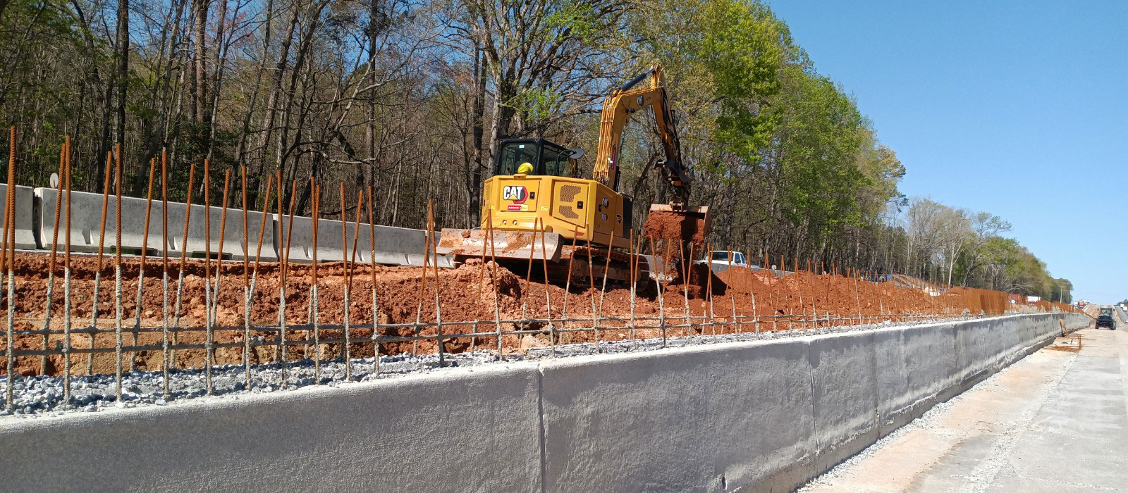 Crews continue to make progress in the median of Segment 3.  Here the median barrier wall is being constructed in stages to accommodate the differences in elevation between the Eastbound and Westbound lanes.  The earthwork must be completed on the high side of the wall before the top level of the concrete barrier can be placed. 