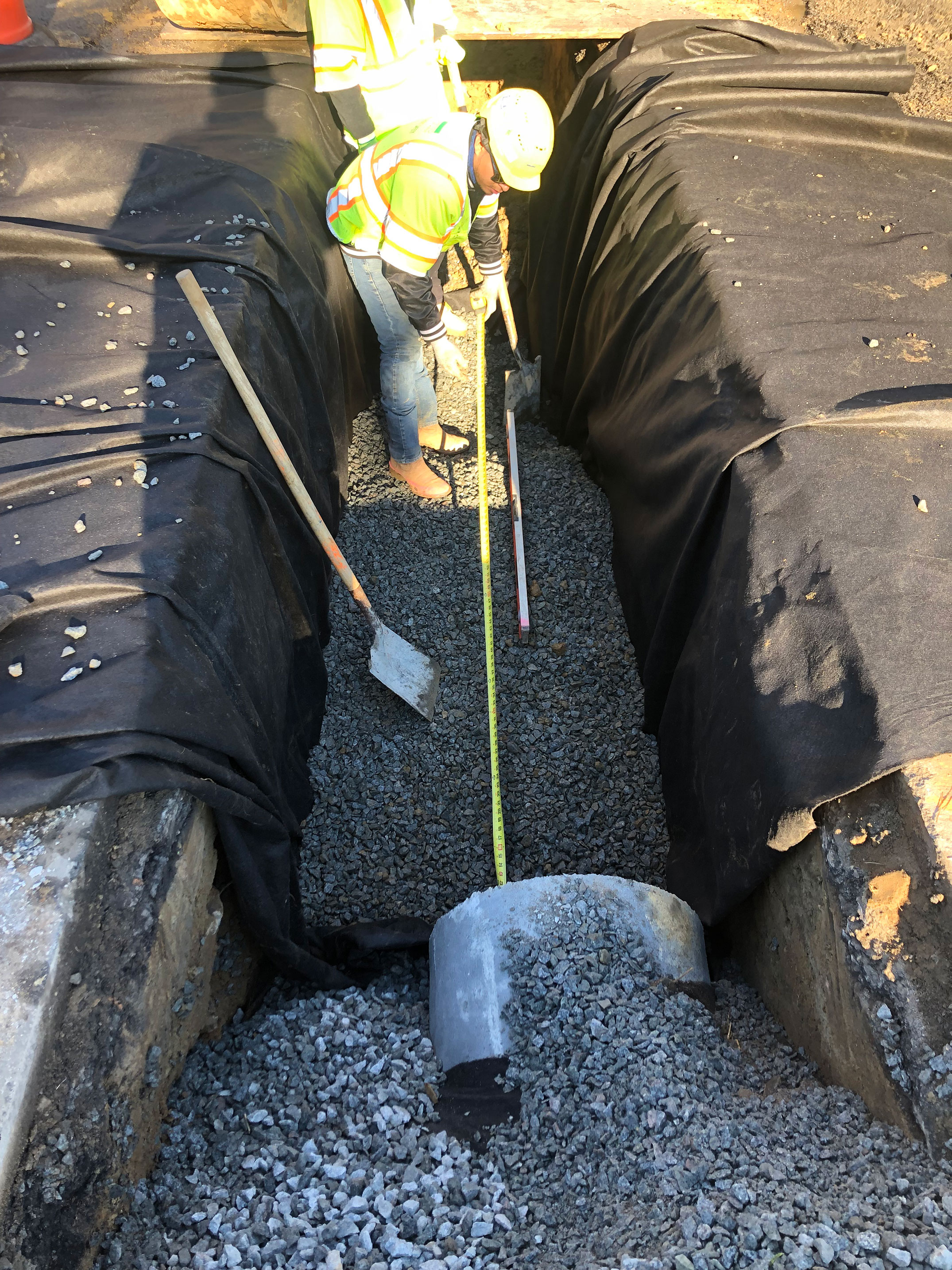 Storm drainage is installed using coarse aggregate for bedding.  The bedding is wrapped in geotextile fabric to create a stable pipe trench.
