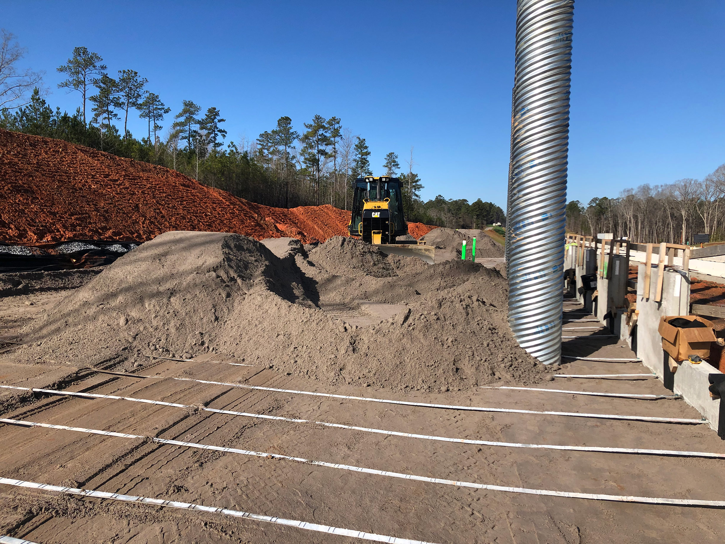 This photo shows construction of the retaining wall on the eastbound side of the I-26 for the future Columbia Avenue overpass at Exit 91.  Panels for the wall are secured in place with metal straps that are encased in compacted backfill.
