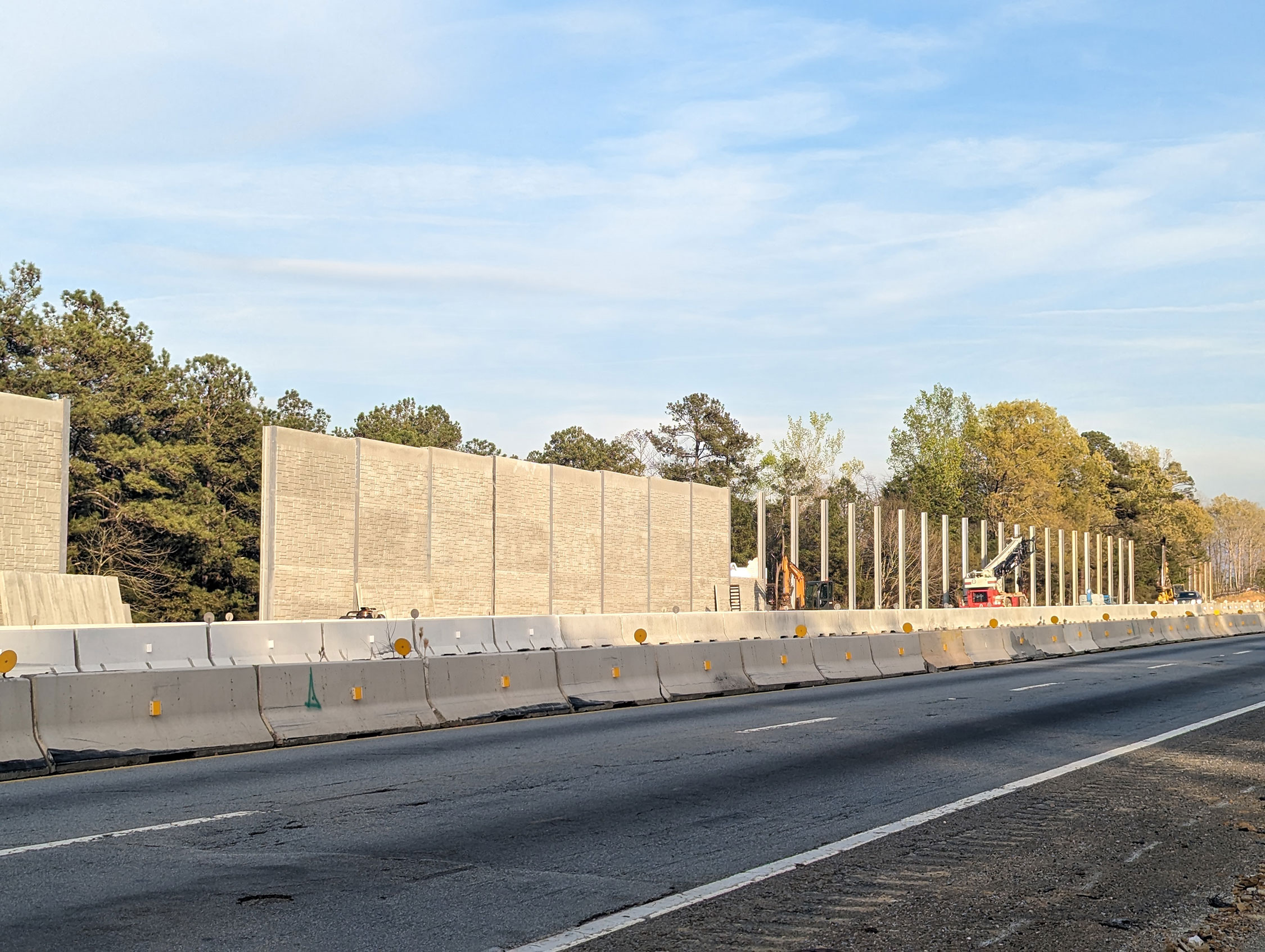 Much progress has been made on the I-26 Westbound sound barrier wall.  The concrete panels are dropped into place between two steel I-beams that are set in a solid concrete foundation.  Some sections of the wall reach 30’ high!