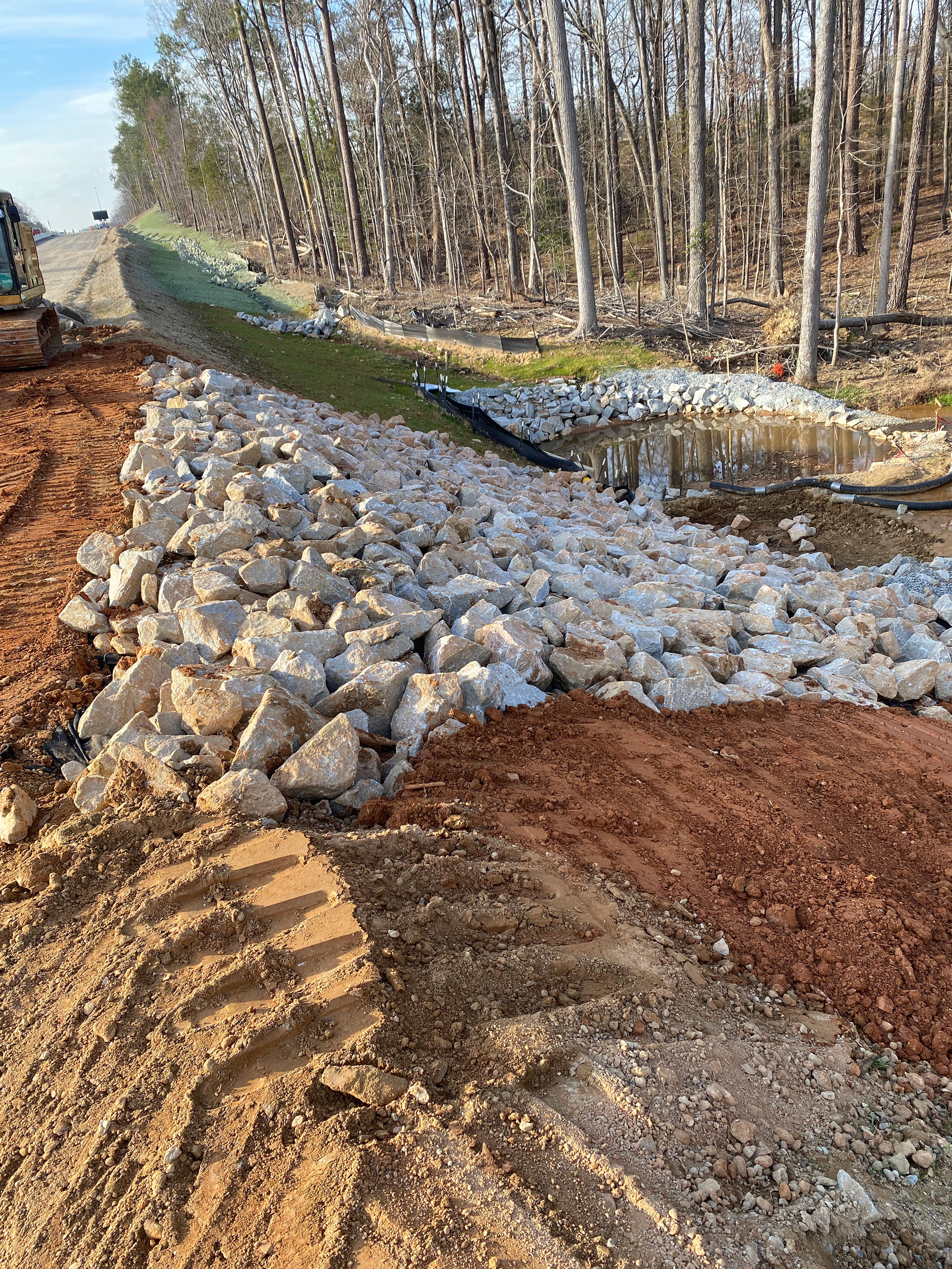 The contractor uses rock called “rip rap” to stabilize the slopes and to trap eroded sediment within the project limits.