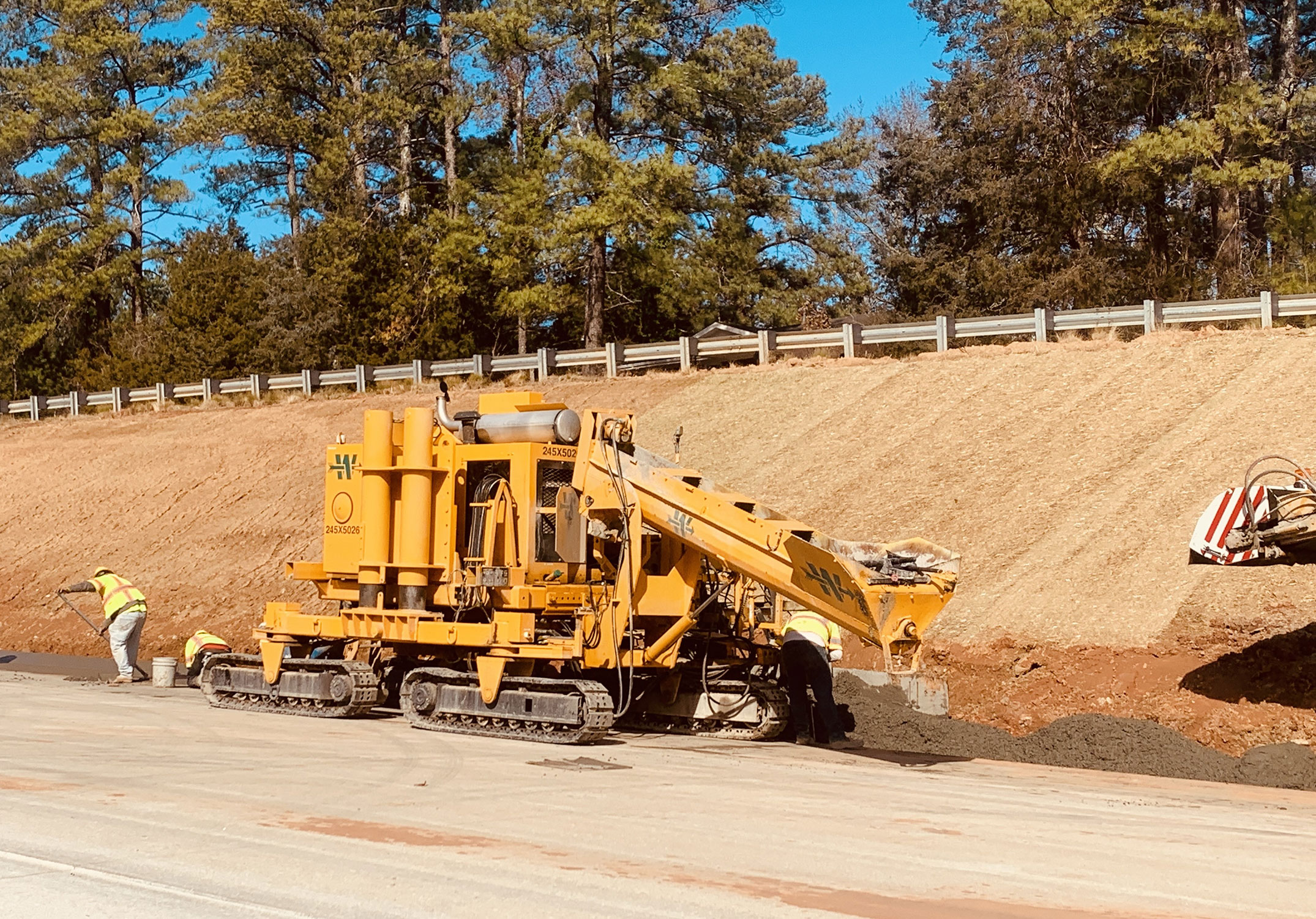 Concrete crews are placing the expressway gutter adjacent to the shoulder of the road.  The gutters will channel water from the roadway to an inlet or drainage ditch.