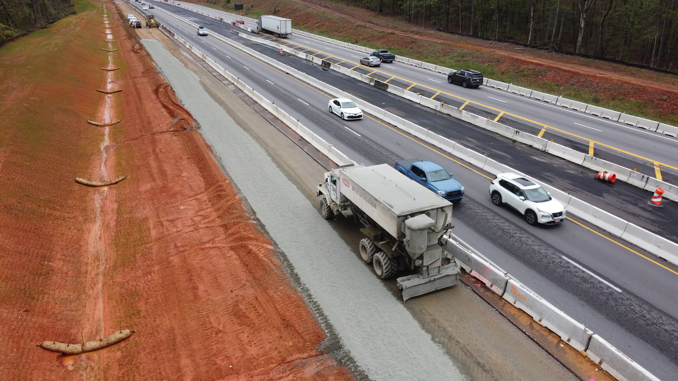 This photo shows the contractor preparing the base for future travel lanes by spreading a layer of cement that is mixed with soil to prepare a solid surface for the pavement structure. This will allow traffic to be shifted to the outside as a part of the staged interstate widening. Upcoming traffic shifts are planned on the westbound lanes between Koon Road and Exit 97.